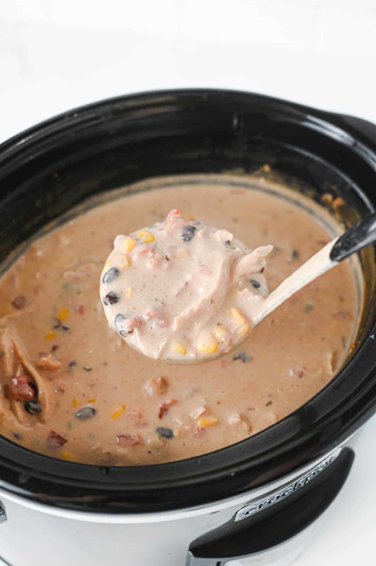 ladling cream cheese chicken chili out of a crock pot