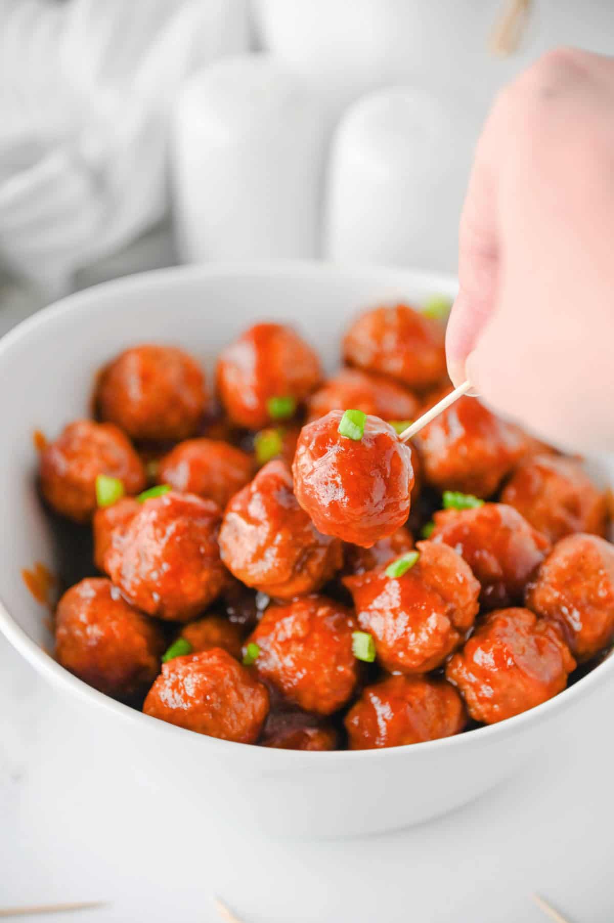 holding a cranberry meatball on a toothpick