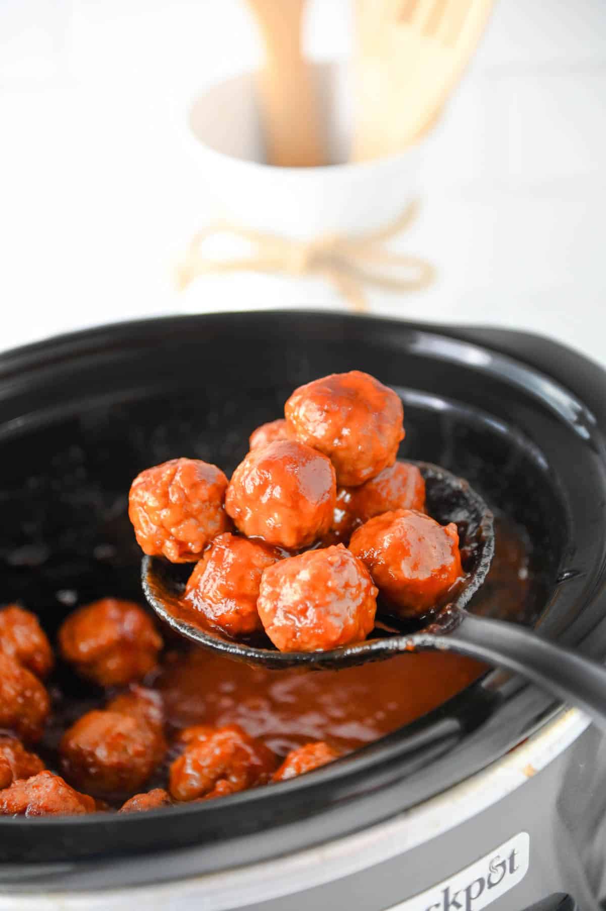 spooning cranberry meatballs out of the slow cooker