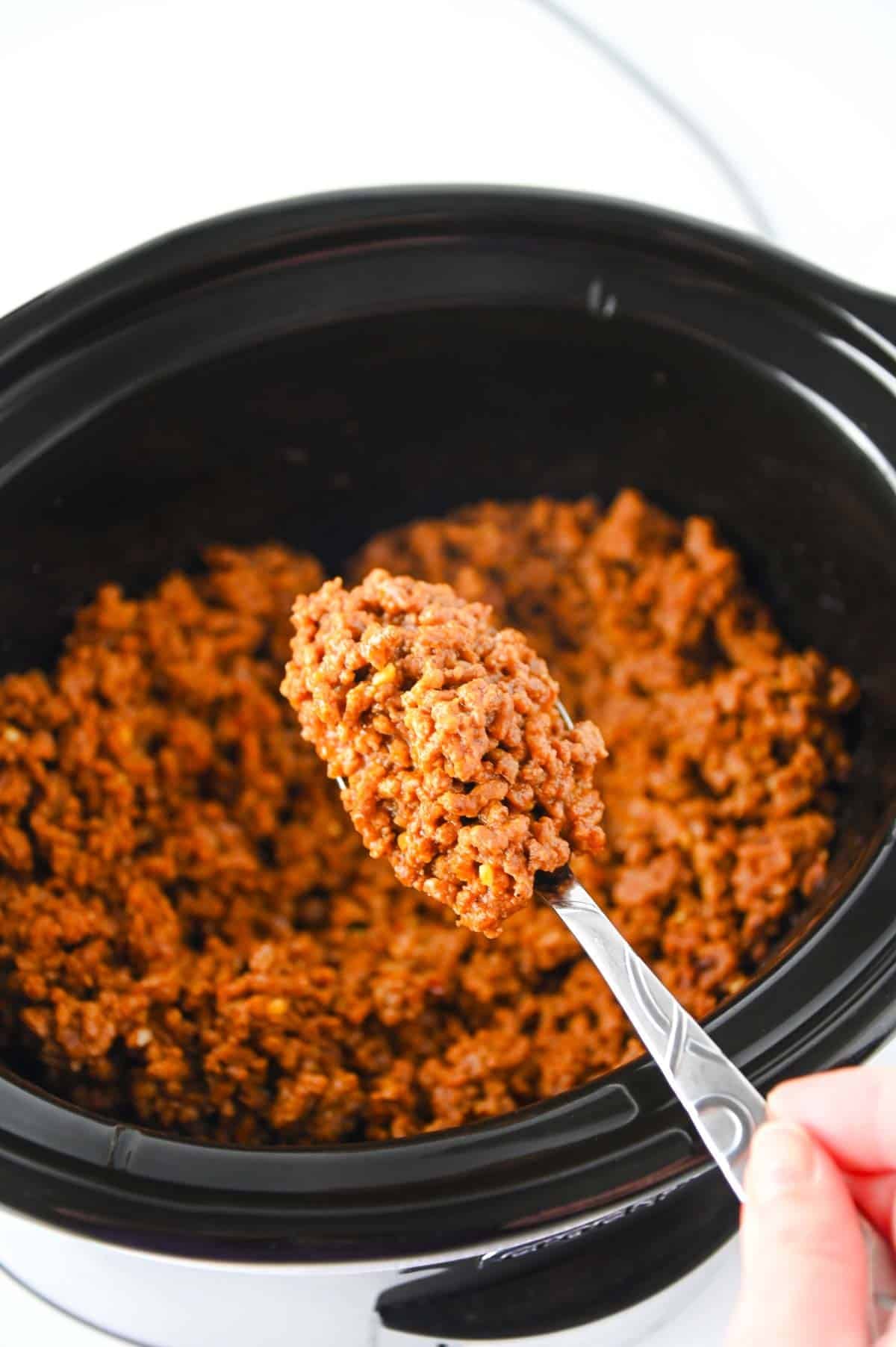 spooning sloppy joe mixture out of crock pot