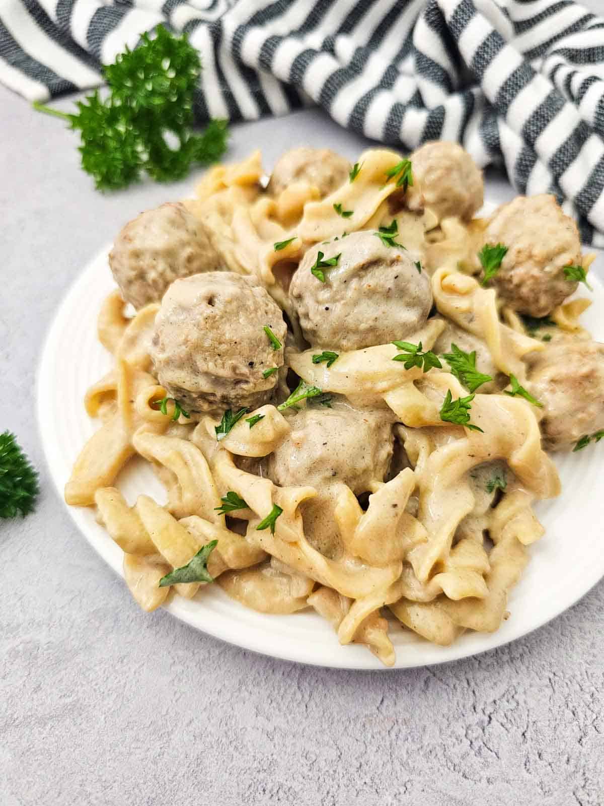 egg noodles and swedish meatballs on a plate