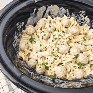 Crock Pot Swedish Meatballs are the ultimate easy slow cooker dinner for busy weeknights! This creamy Swedish meatballs recipe combines frozen meatballs, cream of mushroom soup, brown gravy mix, beef broth, Worcestershire sauce and sour cream for a rich, savoury gravy. Tossed with tender egg noodles, these slow cooker Swedish meatballs make a hearty family dinner with just 10 minutes of prep. If you're looking for easy crock pot meals, frozen meatball recipes, comfort food dinners, simple ground beef dinner ideas or budget friendly family meals, this Crockpot Swedish Meatballs recipe belongs on your menu. Perfect for chilly nights, potluck dinners and meal planning, these creamy meatballs and noodles are a delicious, fuss-free dinner everyone will love!
