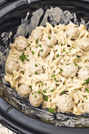 Crock Pot Swedish Meatballs are the ultimate easy slow cooker dinner for busy weeknights! This creamy Swedish meatballs recipe combines frozen meatballs, cream of mushroom soup, brown gravy mix, beef broth, Worcestershire sauce and sour cream for a rich, savoury gravy. Tossed with tender egg noodles, these slow cooker Swedish meatballs make a hearty family dinner with just 10 minutes of prep. If you're looking for easy crock pot meals, frozen meatball recipes, comfort food dinners, simple ground beef dinner ideas or budget friendly family meals, this Crockpot Swedish Meatballs recipe belongs on your menu. Perfect for chilly nights, potluck dinners and meal planning, these creamy meatballs and noodles are a delicious, fuss-free dinner everyone will love!