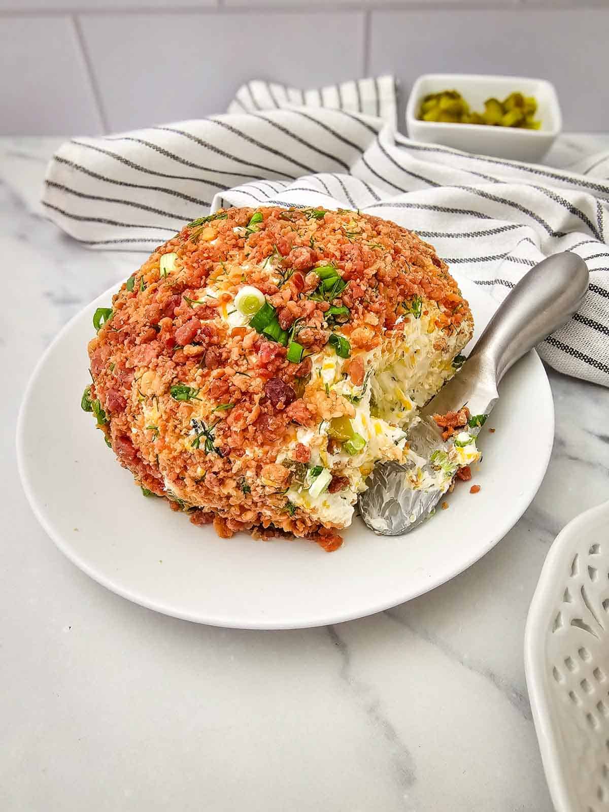 dill pickle cheese ball that's been spread by a knife