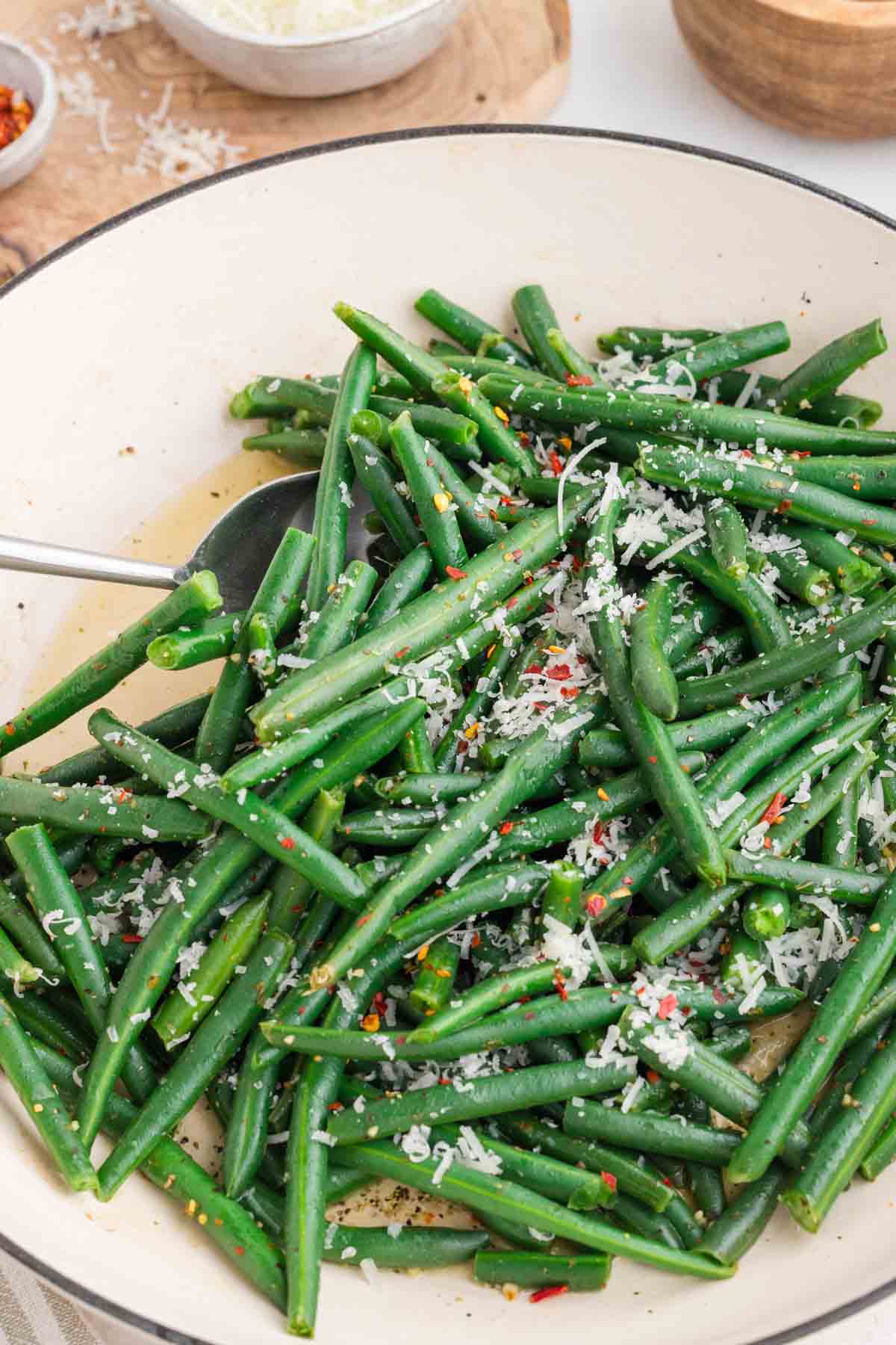 italian green beans with parmesan and chili flakes in a skillet