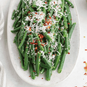These Italian Green Beans are an easy vegetable side dish made with frozen green beans, butter, Italian seasoning, Parmesan cheese, and simple pantry seasonings. This quick skillet green beans recipe is ready in about 15 minutes and makes a flavorful side for chicken dinners, pasta nights, holiday meals, Sunday supper, or busy weeknight dinners. The green beans cook until tender, then get tossed with melted butter and herbs before being topped with salty Parmesan and optional chili flakes. If you need easy side dishes, frozen green bean recipes, Italian side dishes, Parmesan green beans, skillet vegetables, or quick vegetable recipes for family dinners, this simple green beans recipe is a keeper.