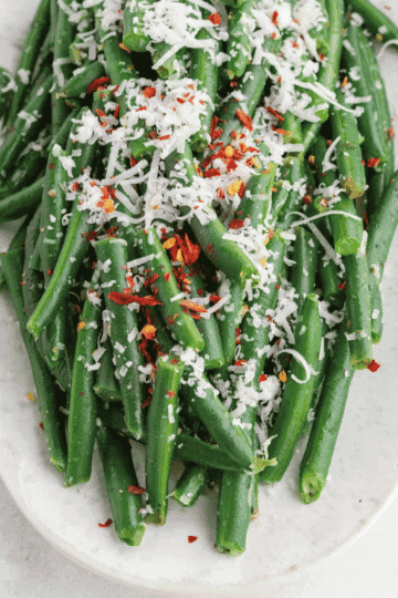 These Italian Green Beans are an easy vegetable side dish made with frozen green beans, butter, Italian seasoning, Parmesan cheese, and simple pantry seasonings. This quick skillet green beans recipe is ready in about 15 minutes and makes a flavorful side for chicken dinners, pasta nights, holiday meals, Sunday supper, or busy weeknight dinners. The green beans cook until tender, then get tossed with melted butter and herbs before being topped with salty Parmesan and optional chili flakes. If you need easy side dishes, frozen green bean recipes, Italian side dishes, Parmesan green beans, skillet vegetables, or quick vegetable recipes for family dinners, this simple green beans recipe is a keeper.