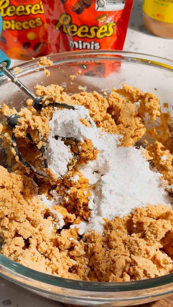 powdered sugar added to mixing bowl with cream cheese mixture