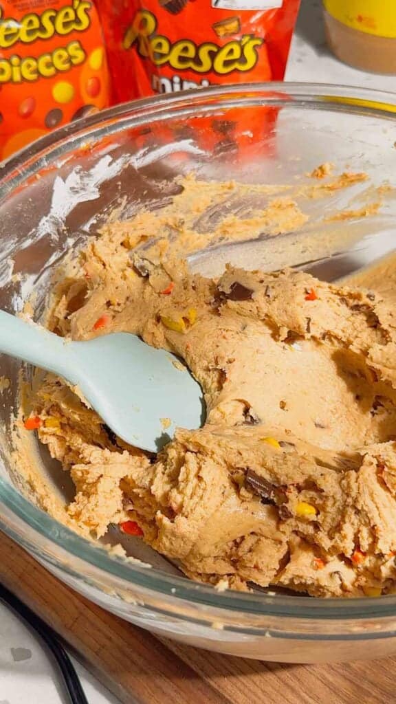 stirring peanut butter cheesecake mixture with a rubber spatula