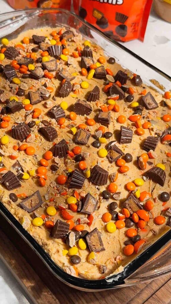 loaded reese's peanut b utter cheesecake in a 9 x 13 inch dish