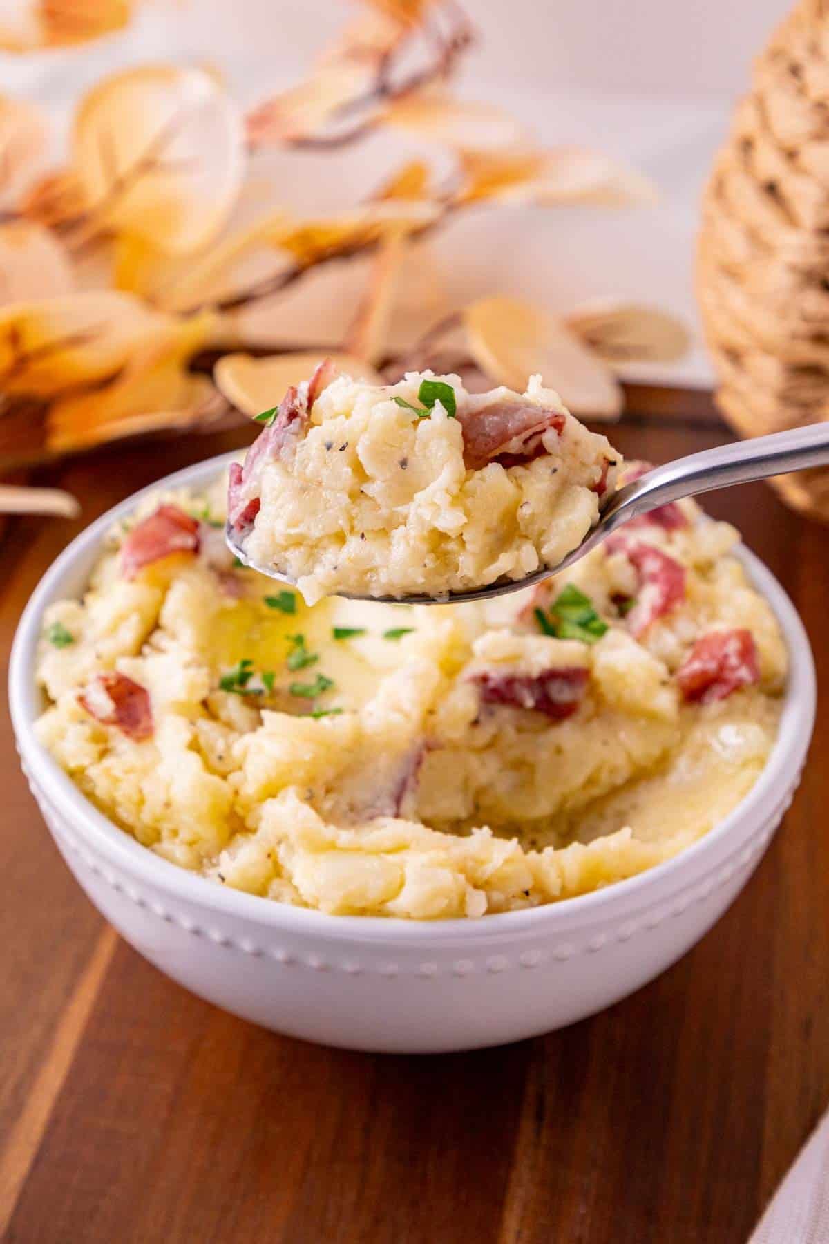 scooping garlic mashed potatoes out of a bowl
