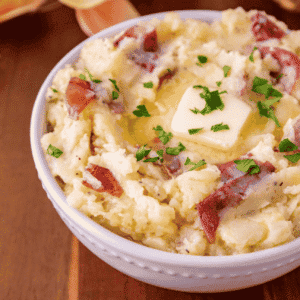 Red Skin Garlic Mashed Potatoes are an easy potato side dish made with red potatoes, butter, fresh garlic, milk, and Parmesan cheese. These creamy garlic mashed potatoes have tender potato skins in every bite, so you can skip the peeling and get this family favourite on the table in just 30 minutes. Serve these buttery Parmesan mashed potatoes with meatloaf, roast chicken, steak, or pork chops for an easy weeknight dinner. This red skin mashed potatoes recipe is also perfect for Thanksgiving dinner, Christmas dinner, Sunday supper, and holiday meals. Mash them smooth or leave them chunky, then finish with extra butter and fresh herbs. Save this homemade mashed potatoes recipe for a simple, comforting side dish everyone will want seconds of!