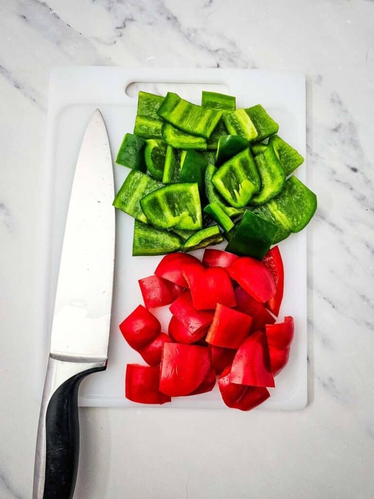 chopped red and green bell peppers on a cutting board