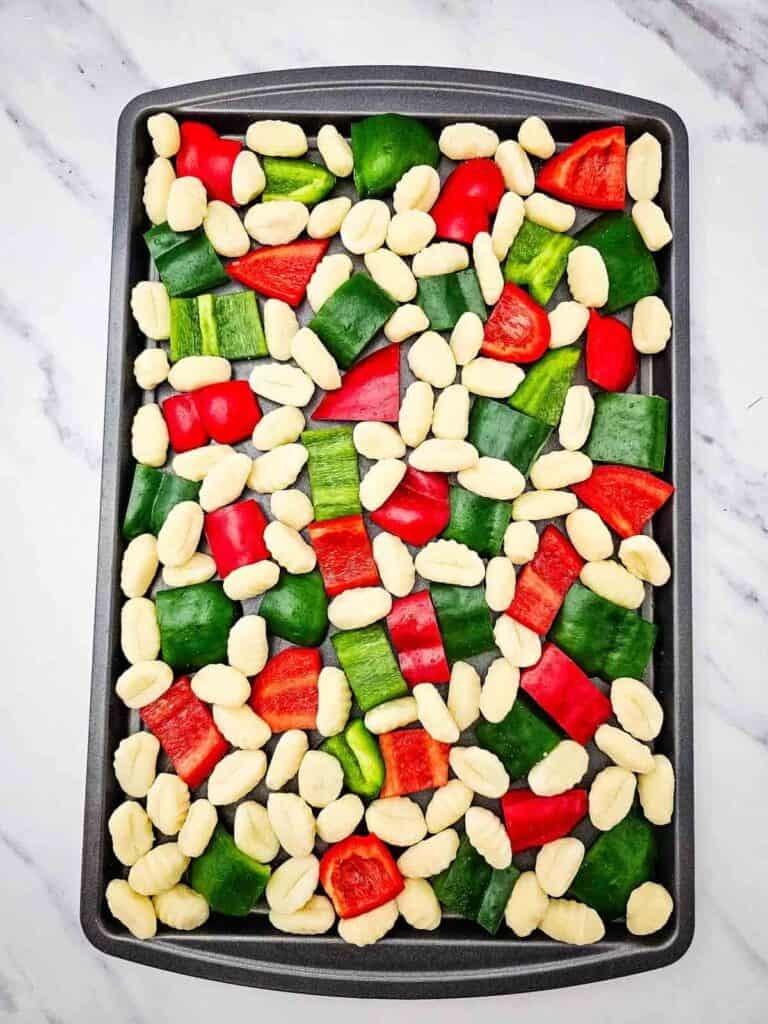 bell peppers and gnocchio on a baking sheet