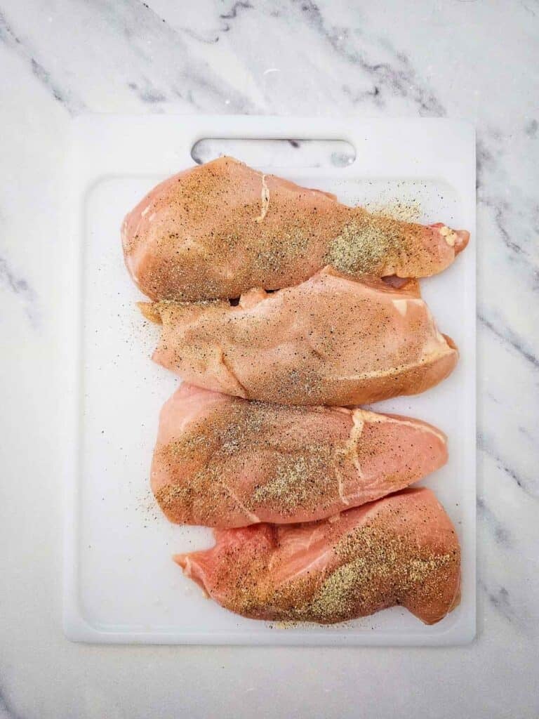 seasoned chicken breasts on a cutting board