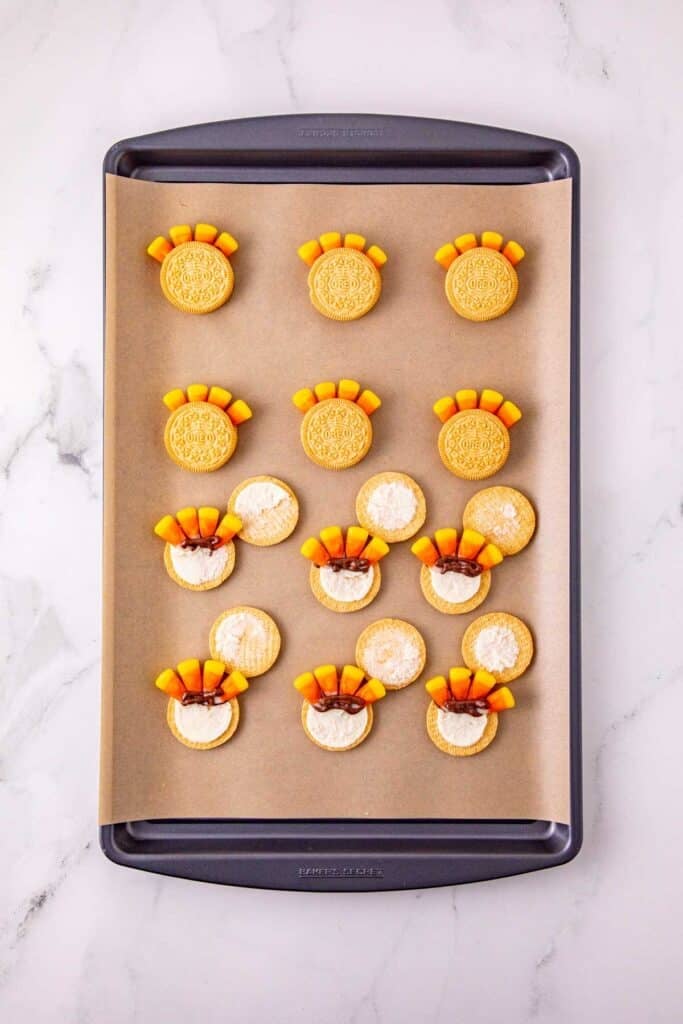 candy corn being stuck to filling of golden oreos to make turkey tails