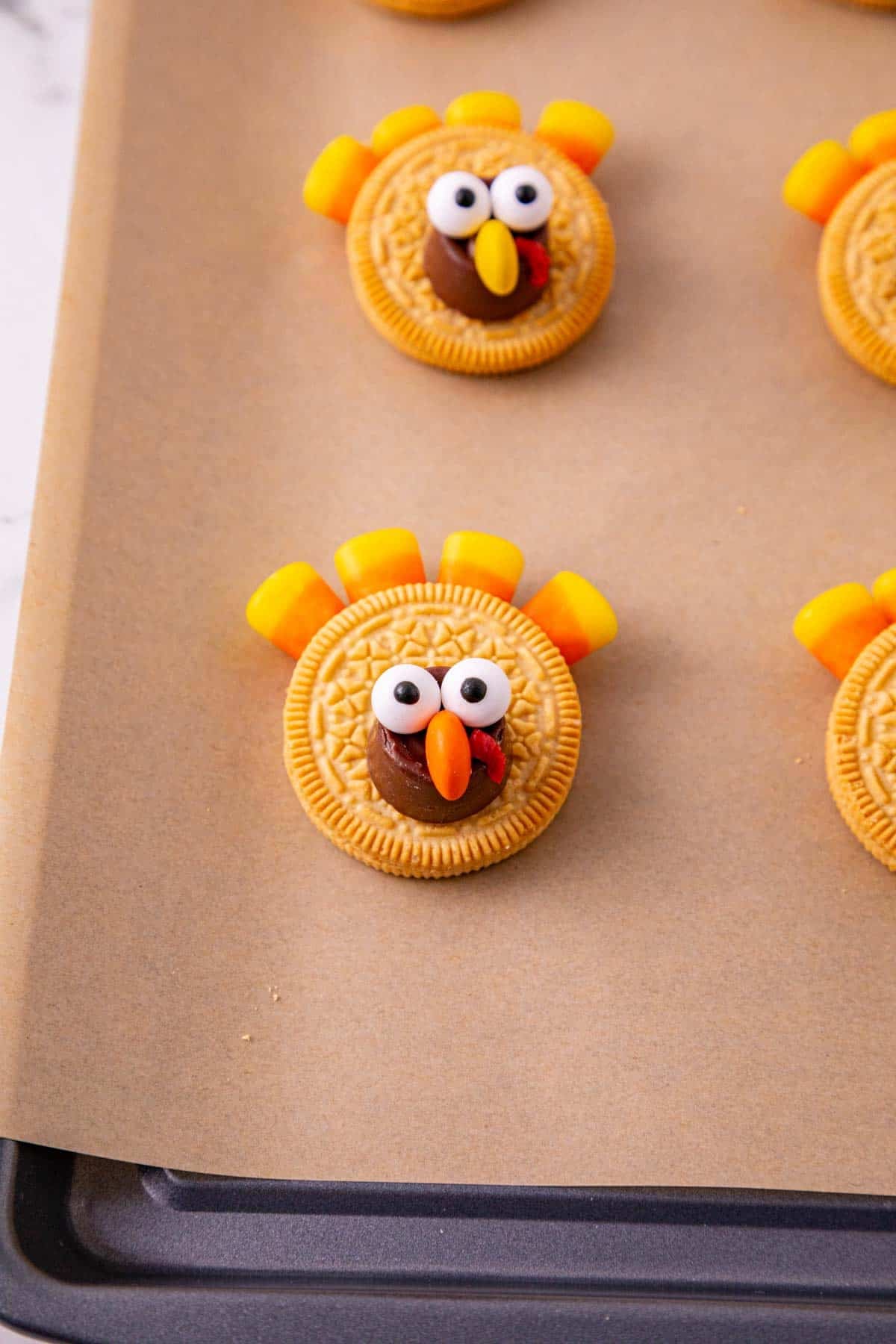 golden oreo turkey cookies on parchment paper