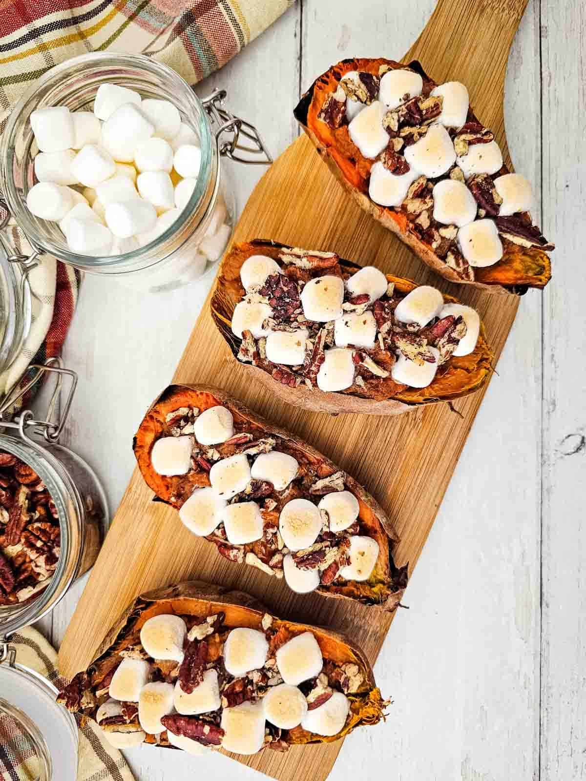 toasted marshmallow topped baked sweet potatoes on a serving platter