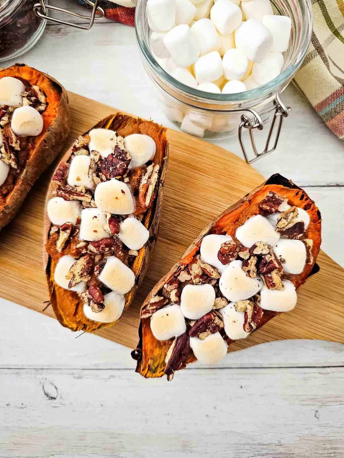 marshmallow topped baked sweet potatoes on a serving board