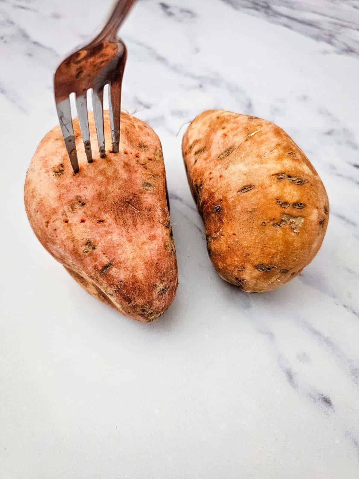 sticking a fork in a cooked sweet potato