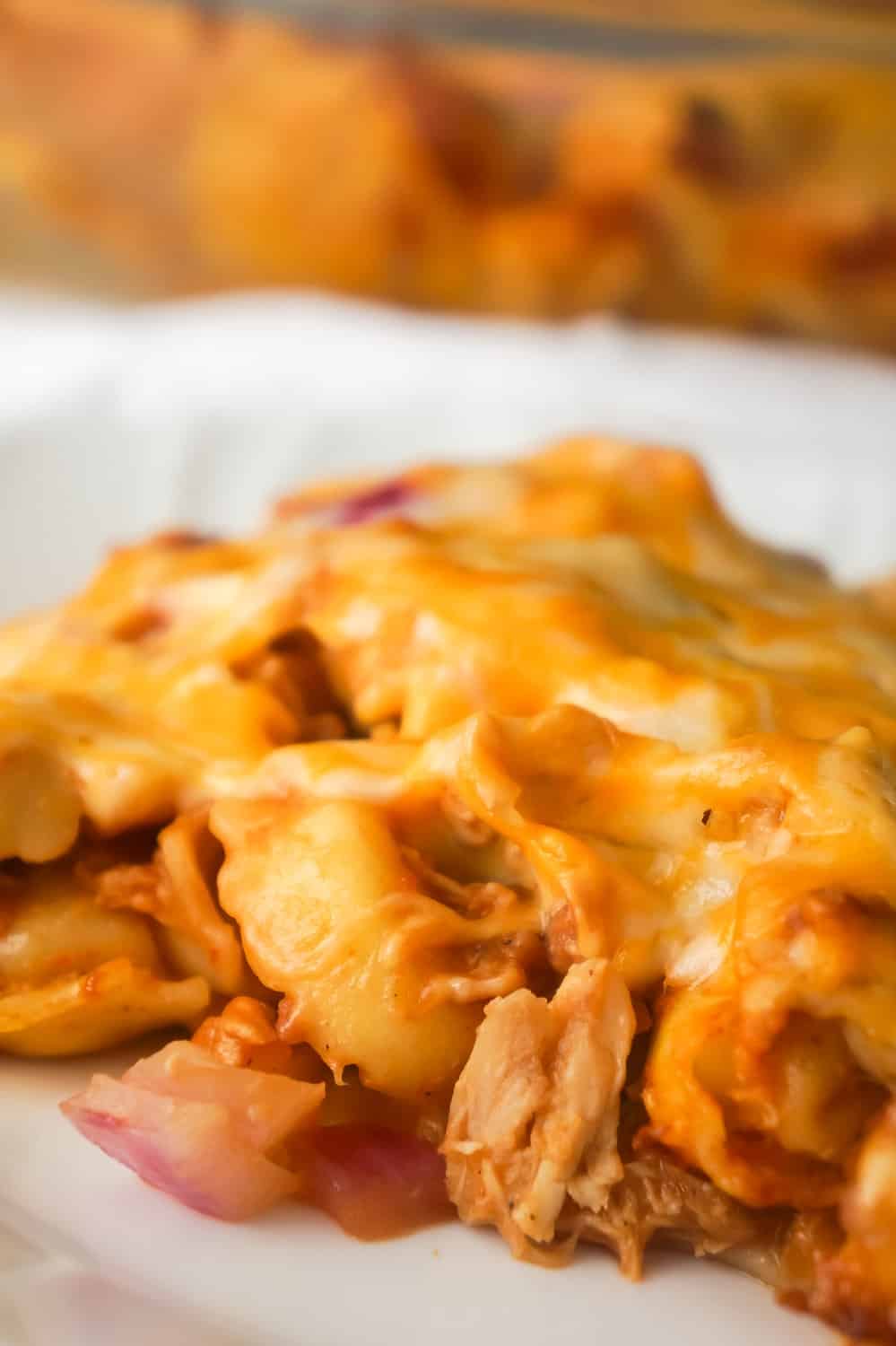 BBQ Chicken Tortellini Casserole is an easy dinner recipe using rotisserie chicken. This baked tortellini is loaded with bacon, chicken, red onions, BBQ sauce and cheddar cheese.