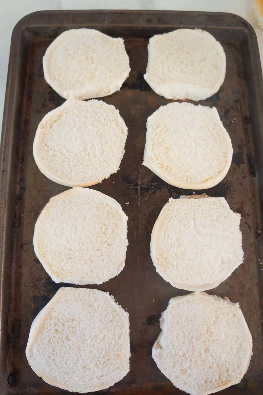 hamburger buns on baking sheet