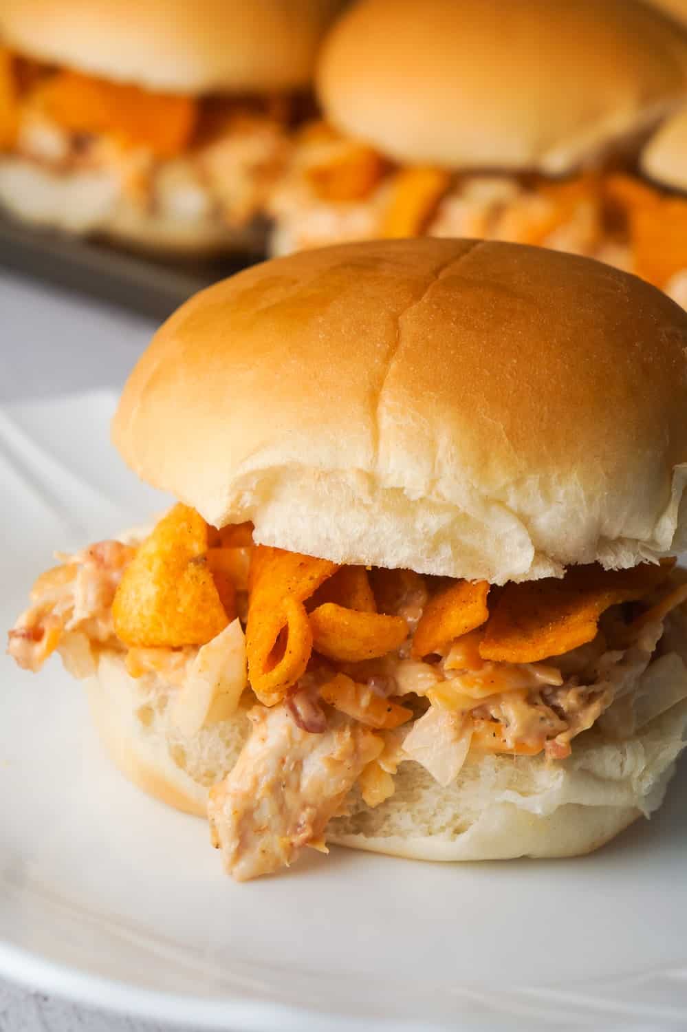 BBQ Fritos Chicken Sandwiches are an easy dinner recipe using shredded chicken and loaded with BBQ corn chips, cheddar cheese and bacon. This recipe is perfect for summer because if you use a grocery store rotisserie chicken you won't even have to turn on the oven.