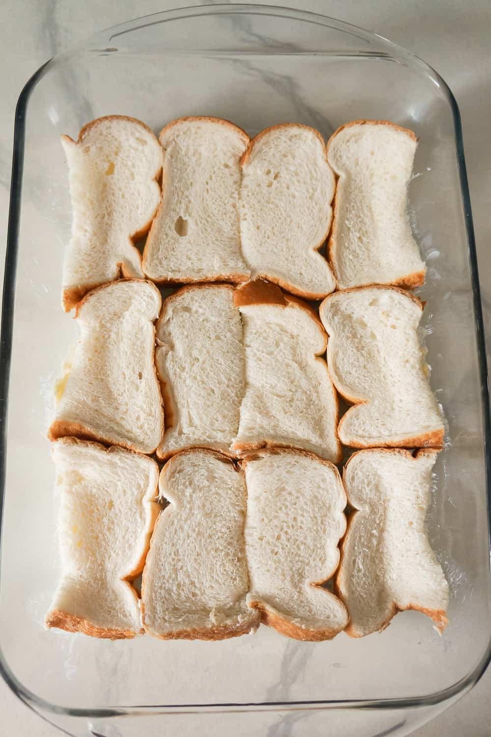 bread slices in the bottom of a 9 x 13 inch baking dish