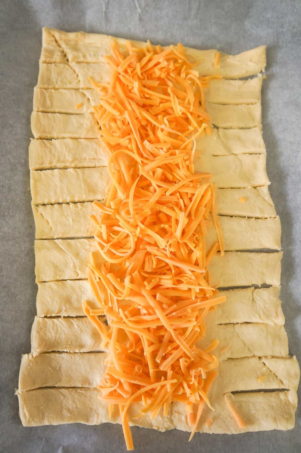 crescent dough topped with shredded cheddar cheese