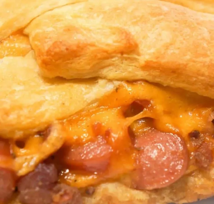 Bacon Cheese Dog Crescent Braid is an easy weeknight dinner recipe. This crescent bake is stuffed with wieners, bacon and cheese then topped with chili to make it a hearty comfort food dish.