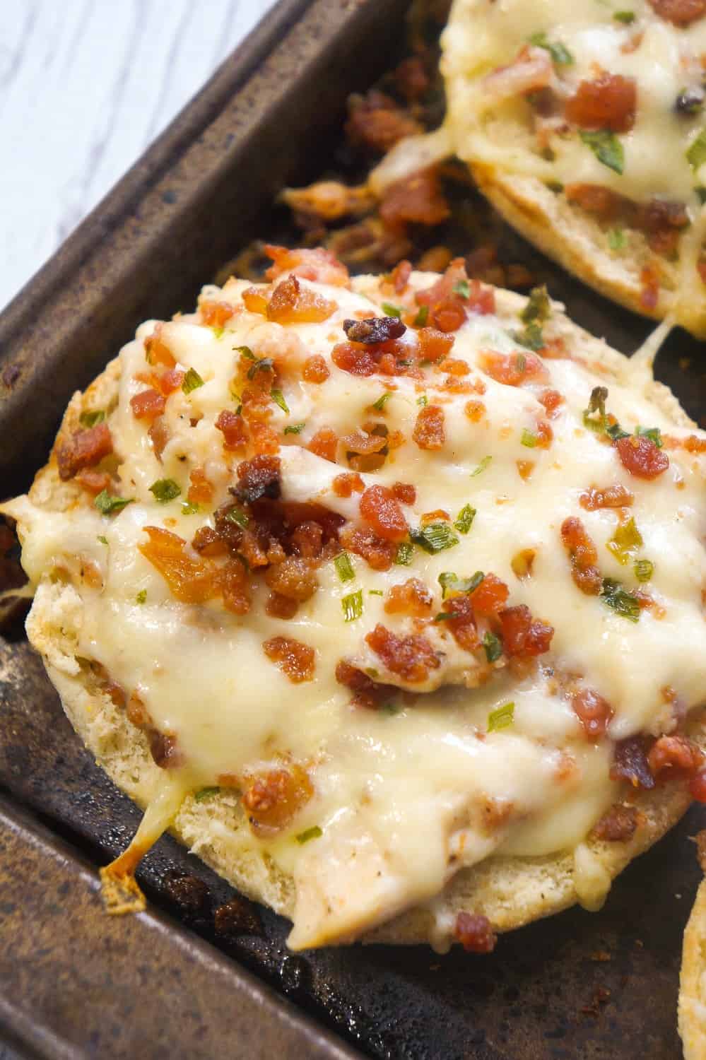 Bacon Chicken Alfredo English muffins are an easy dinner recipe or perfect party snack. These baked English muffins are loaded with shredded rotisserie chicken, bacon, cheese and Alfredo sauce.