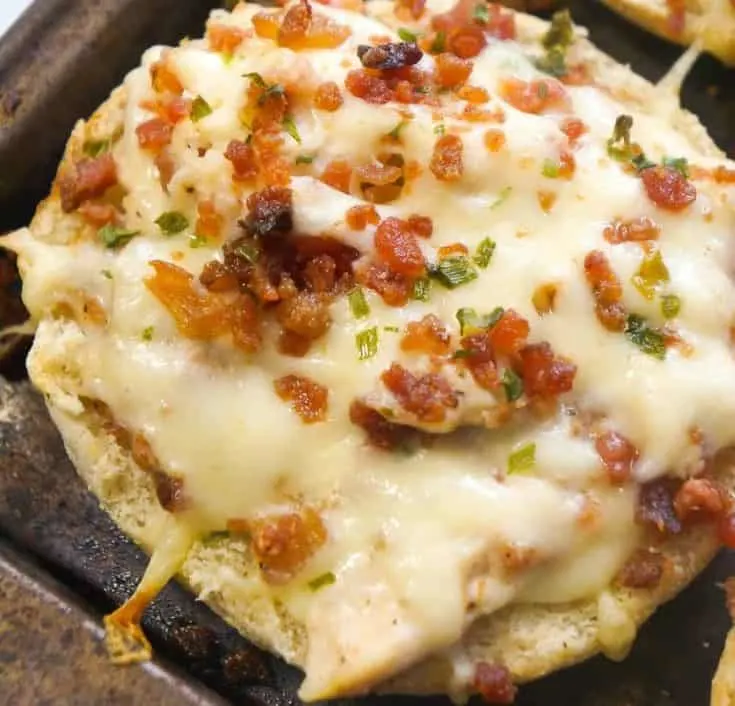 Bacon Chicken Alfredo English muffins are an easy dinner recipe or perfect party snack. These baked English muffins are loaded with shredded rotisserie chicken, bacon, cheese and Alfredo sauce.