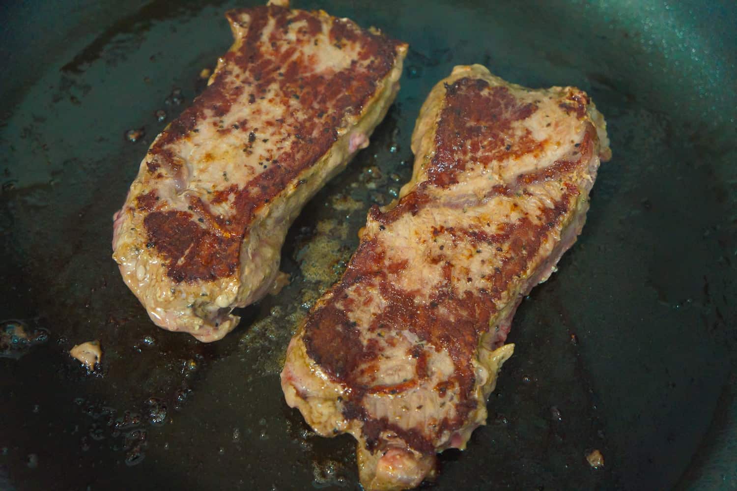 steaks in frying pan