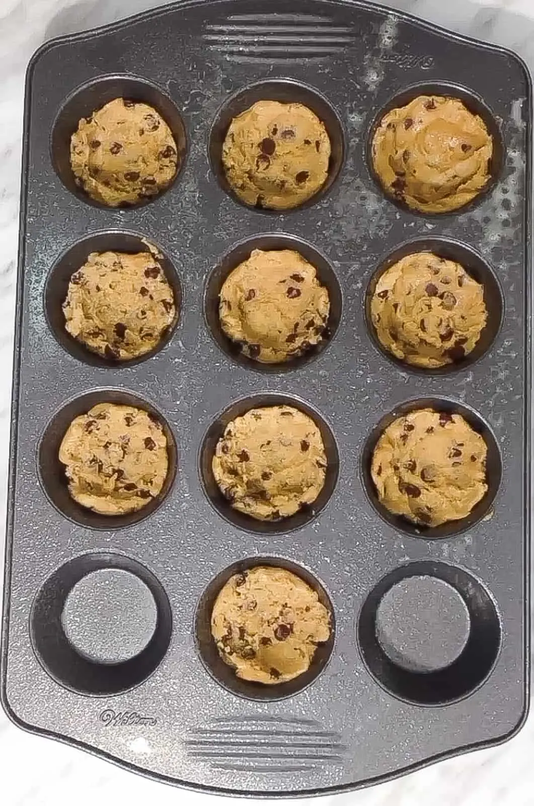 chocolate chip cookie dough in muffin tins