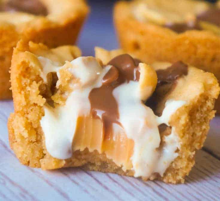 Caramel Peanut Butter Cookie Cups are an easy peanut butter dessert recipe. These cookie cups are filled with caramels, mini peanut butter cups, white chocolate peanut butter cups and roasted peanuts.