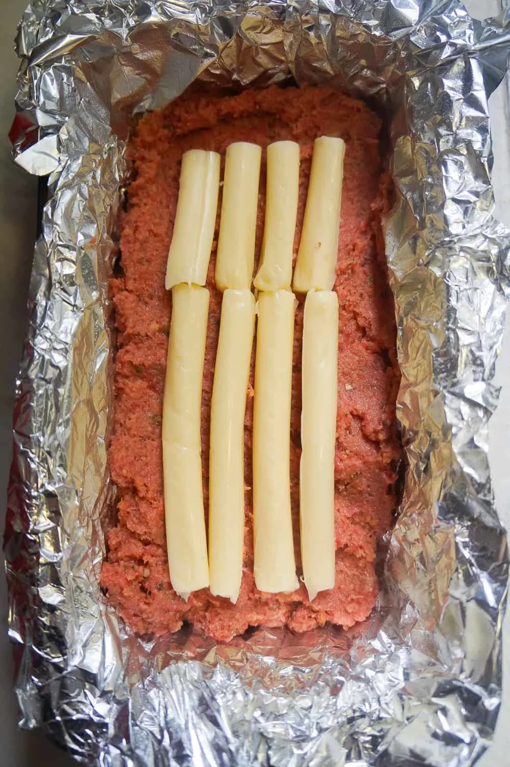 string cheese in the center of uncooked ground chicken meatloaf