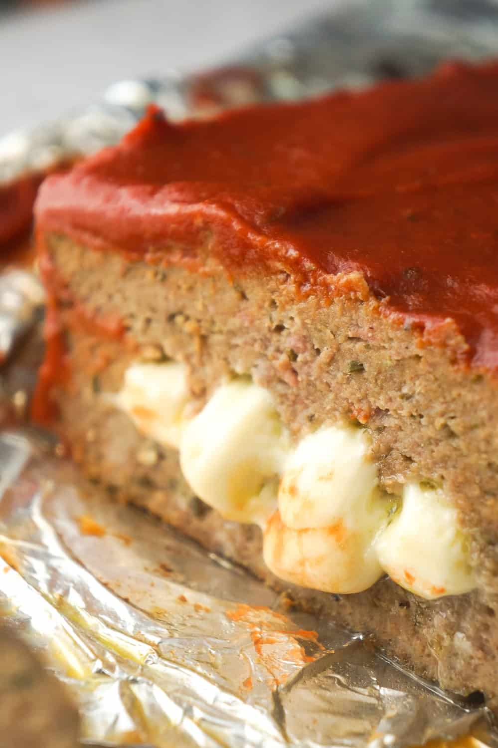 Cheese Stuffed Ground Chicken Meatloaf is an easy dinner recipe loaded with Italian flavours. This chicken meatloaf is made with Italian seasoned bread crumbs, basil pesto, mozzarella cheese and topped with pizza sauce.