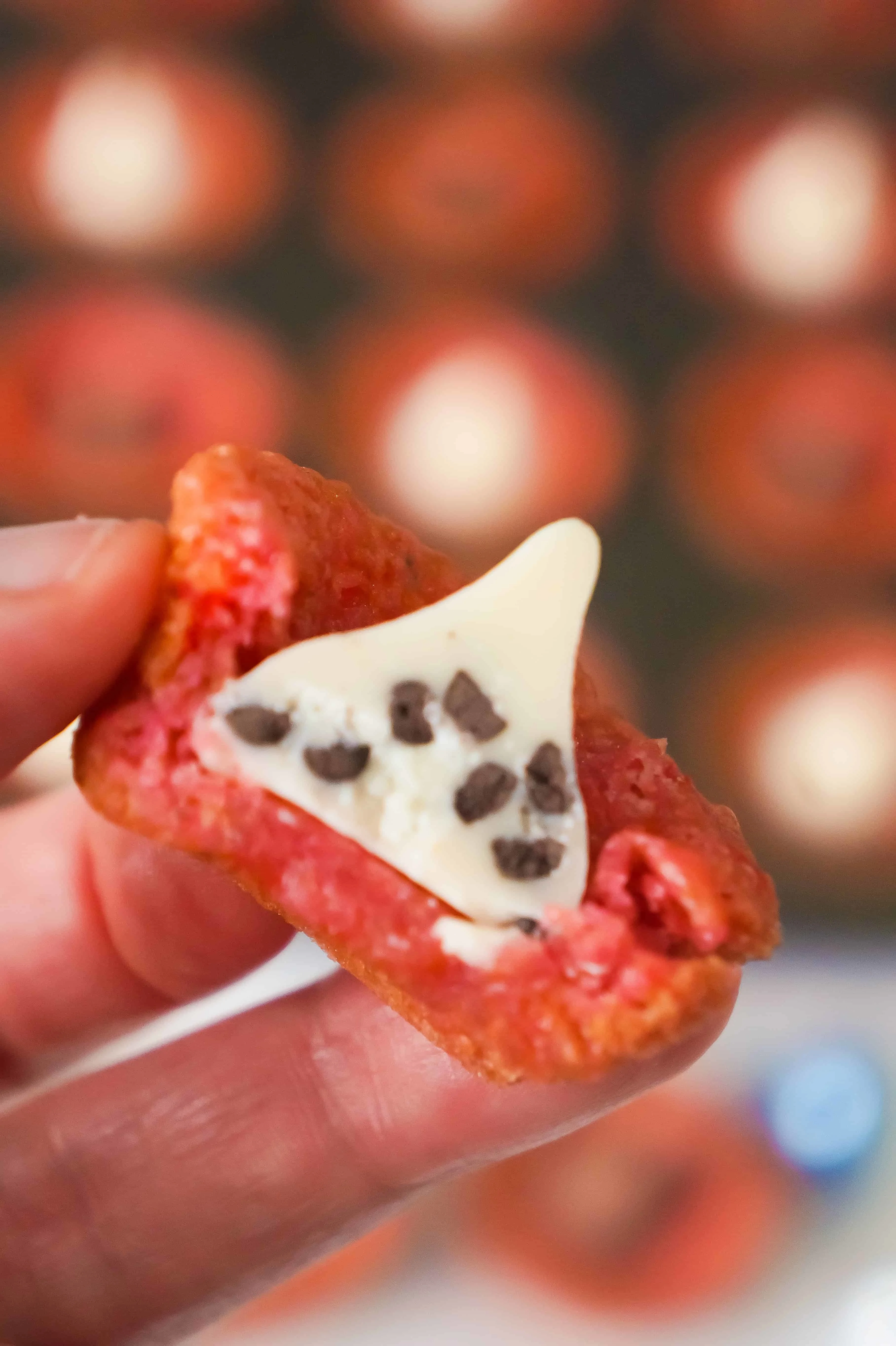 Cherry Jello Sugar Cookie Cups are made in mini muffin tins and topped with Hershey's Kisses.