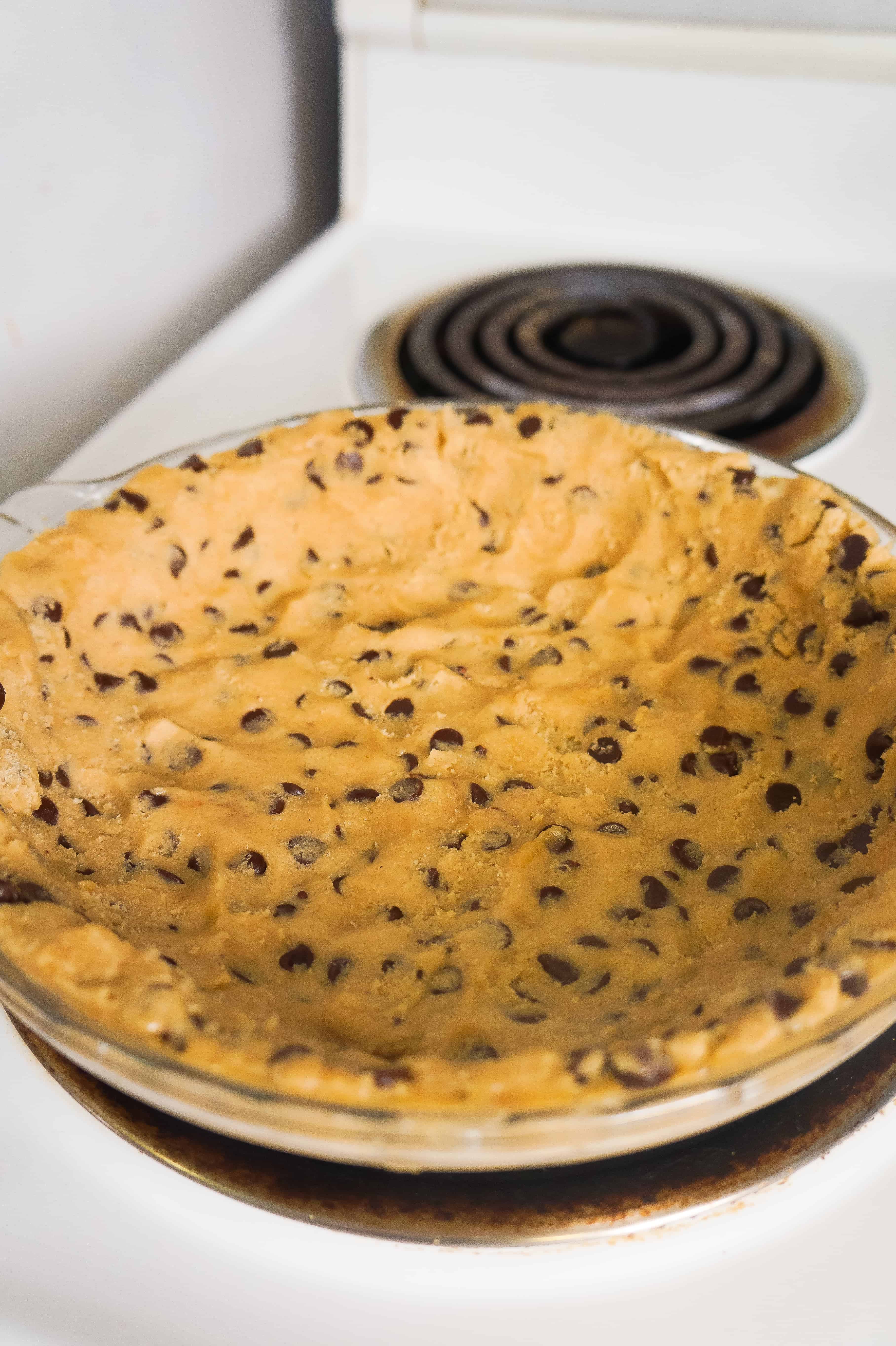 Chocolate chip cookie dough in a pie plate.