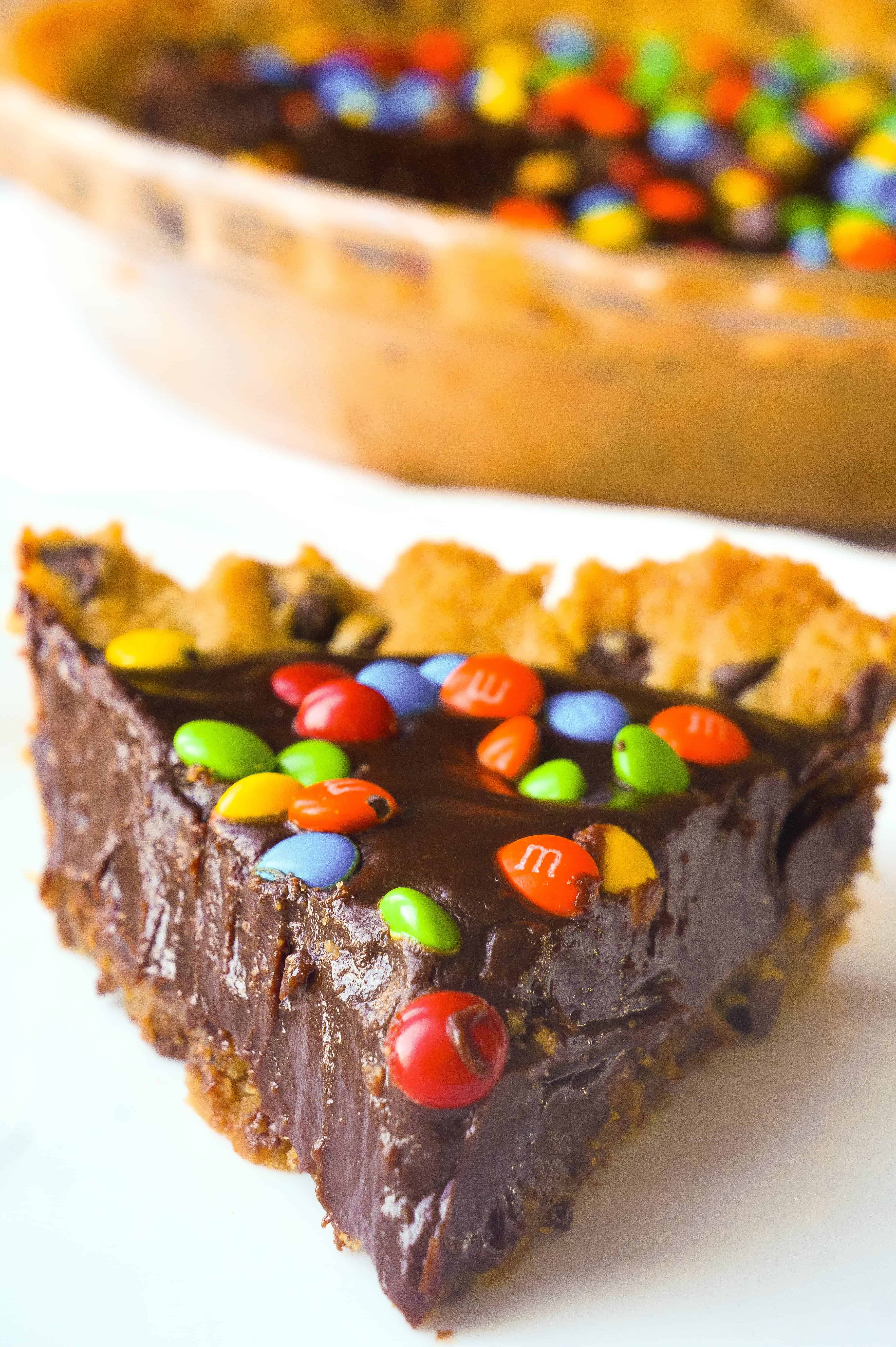 Chocolate Fudge Cookie Pie is a decadent dessert for chocolate lovers. This easy pie recipe starts with a chocolate chip cookie crust with a creamy chocolate filling and is topped with mini M&Ms.