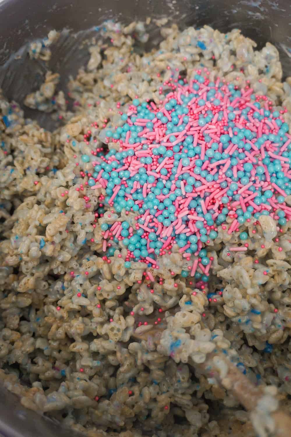 pink and blue sprinkles added to cotton candy rice krispie mixture