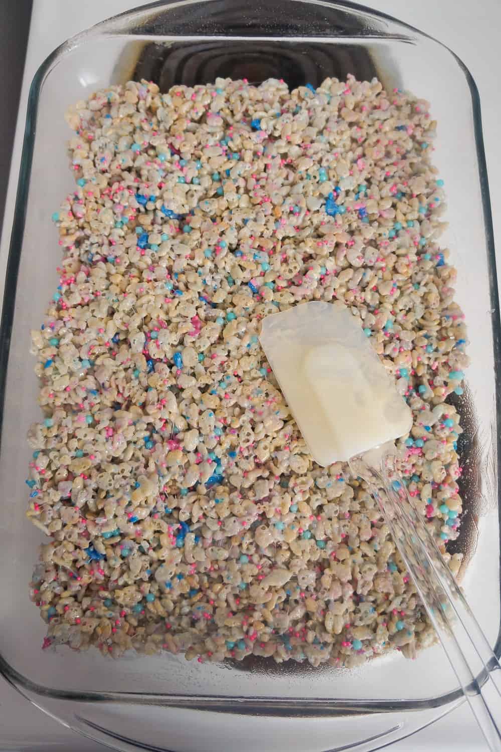 rubber spatula spreading rice krispie treats in pan