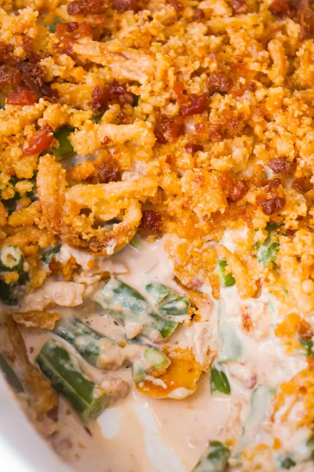 Cream Cheese and Bacon Green Bean Casserole is an easy side dish recipe perfect for Thanksgiving or Christmas. This creamy green bean casserole is loaded with real bacon bits and topped with Ritz Crackers and French's Fried Onions.