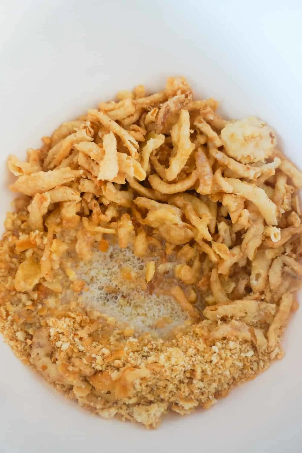 crushed Ritz crackers, fried onions and melted butter in a mixing bowl