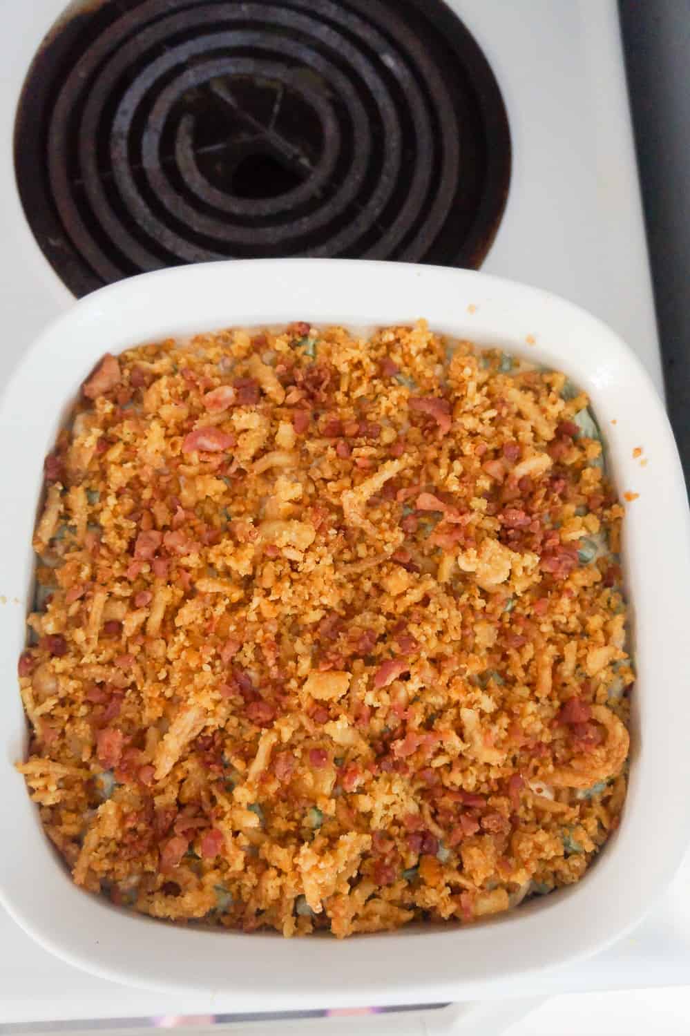 Ritz cracker and fried onions on top of green bean casserole in baking dish