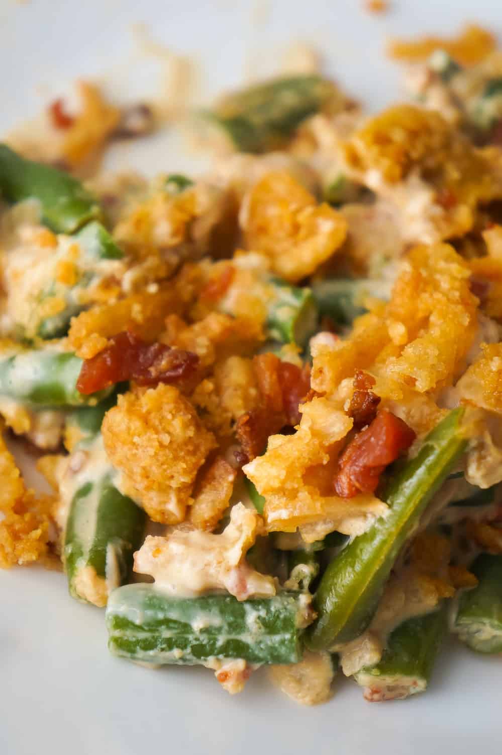 Cream Cheese and Bacon Green Bean Casserole is an easy side dish recipe perfect for Thanksgiving or Christmas. This creamy green bean casserole is loaded with real bacon bits and topped with Ritz Crackers and French's Fried Onions.