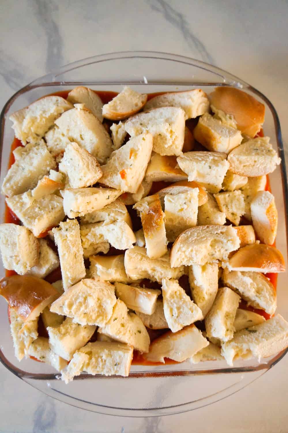 chopped bagels on top of ground chicken casserole