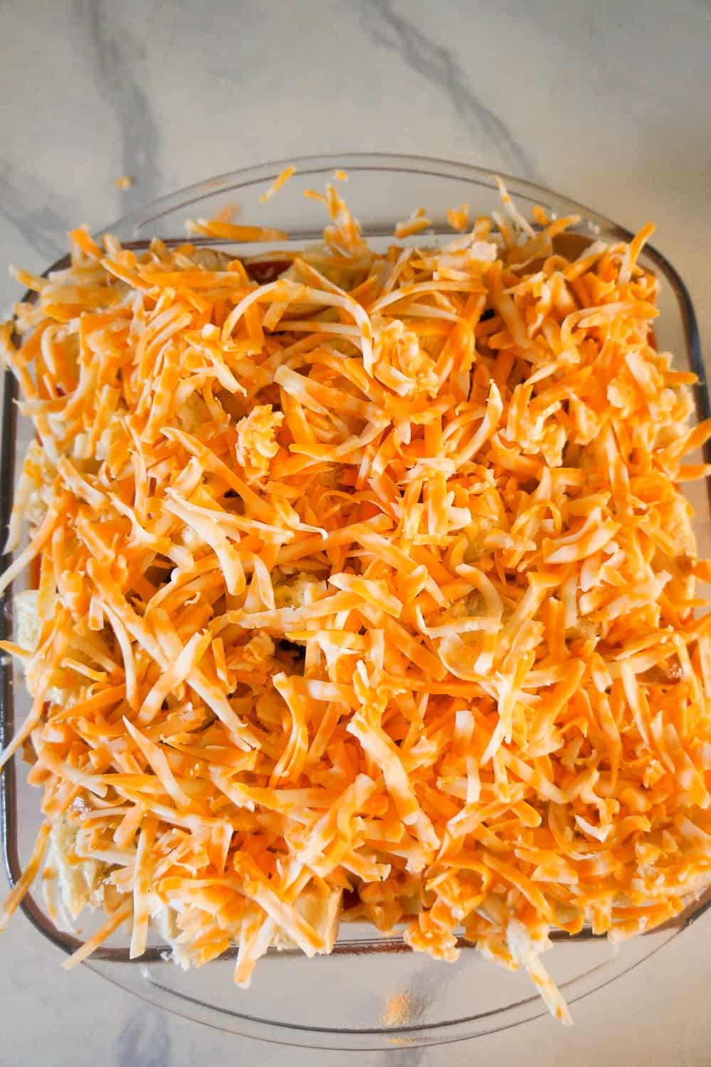 shredded cheddar cheese on top of ground chicken casserole