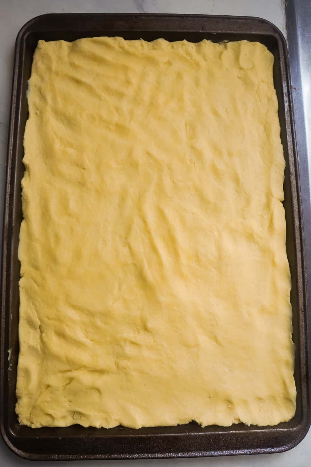 lemon pudding sugar cookie dough pressed out into baking pan