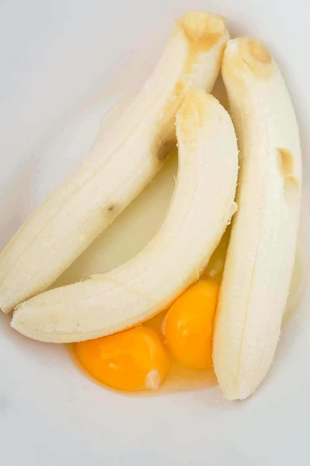ripe bananas and eggs in a large mixing bowl